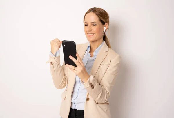 Junge Geschäftsfrau Benutzt Smartphone Mit Siegeszeichen Isoliert Vor Weißem Hintergrund — Stockfoto