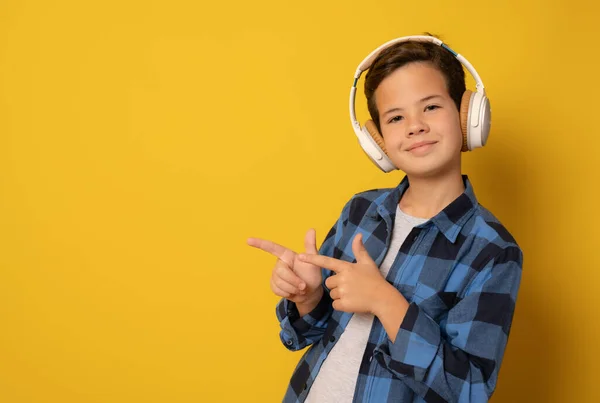 Jovem Menino Caucasiano Usando Fones Ouvido Ouvindo Música Apontando Lado — Fotografia de Stock