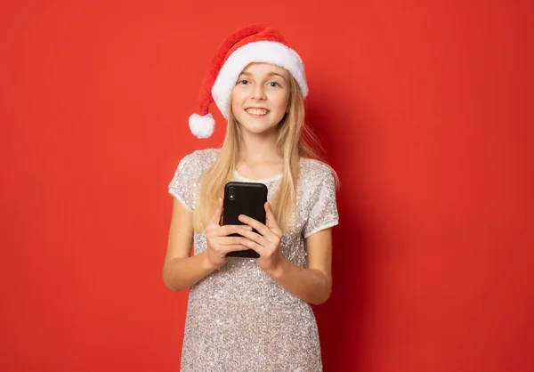 Menina Sorridente Vestindo Chapéu Santa Usando Smartphone Isolado Sobre Fundo — Fotografia de Stock