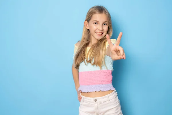 Feliz Linda Niña Pie Mostrando Símbolo Paz Sobre Fondo Azul —  Fotos de Stock