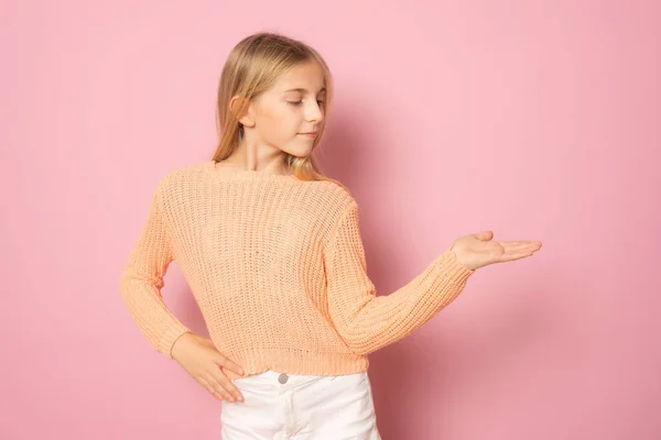 Κοριτσάκι Casual Ρούχα Που Δείχνει Προϊόν Χέρι Στέκεται Απομονωμένο Πάνω — Φωτογραφία Αρχείου