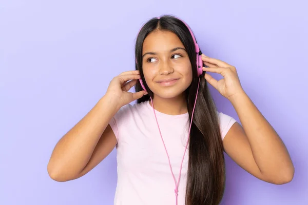 Brunette Hispanic Girl Wearing Headphones Listening Music Purple Background — Zdjęcie stockowe