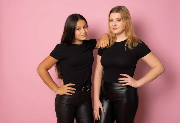 Dvě Dívky Přátelé Černém Pózují Společně Stojící Nad Růžovým Pozadím — Stock fotografie