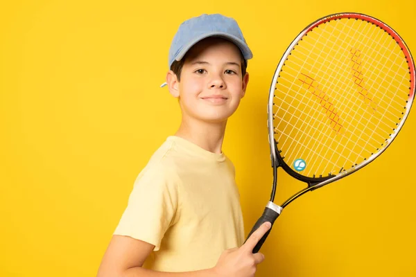Улыбающийся Мальчик Играет Теннис Держа Ракетку Изолированы Желтом Фоне — стоковое фото