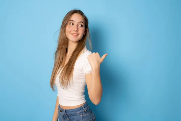 Smiling Girl Long Hair Showing Thumb Side Looking Away Blue — Stockfoto