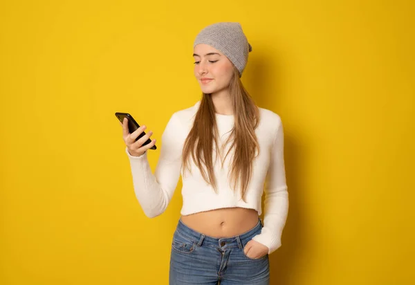 Beautiful Young Woman Wearing Winter Hat Using Smartphone Standing Isolated — Fotografia de Stock