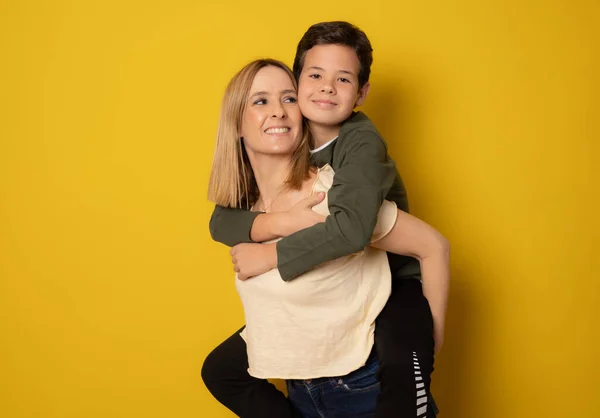 Mãe Filho Uma Pose Amorosa Isolada Fundo Amarelo — Fotografia de Stock