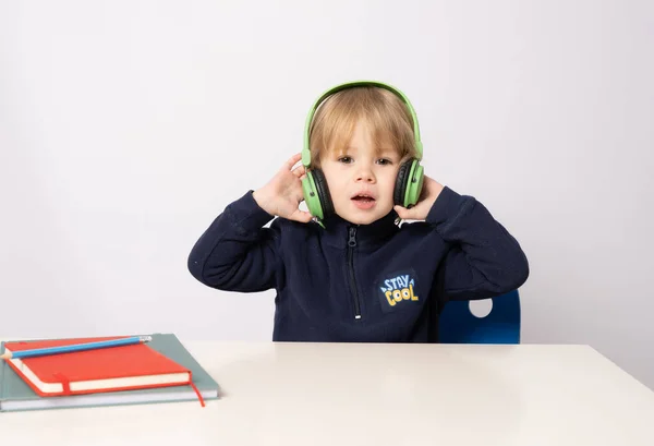 Close Portret Cute Little Boy Noszenia Słuchawki Siedzi Przy Stole — Zdjęcie stockowe