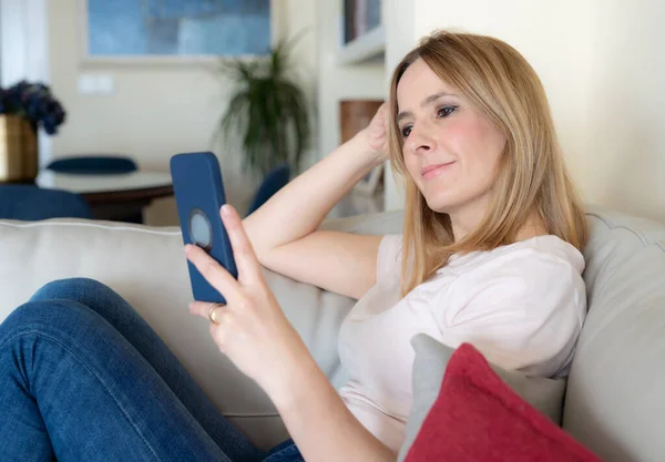 Lächelnde Junge Frau Entspannt Mit Smartphone Hause Auf Sofa Sitzen — Stockfoto