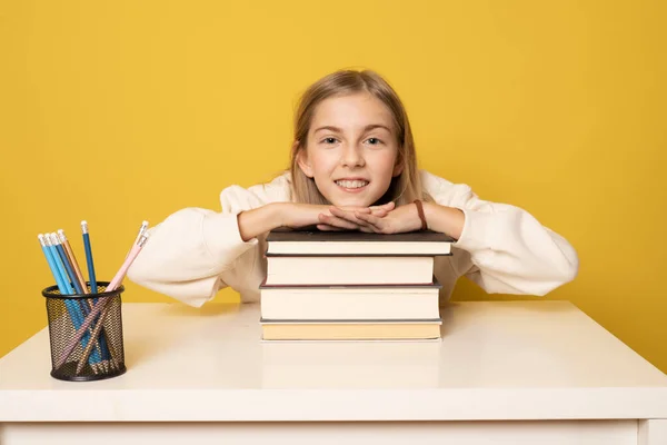 Hermosa Chica Sonriente Sentada Escritorio Con Montón Libros Sobre Fondo —  Fotos de Stock