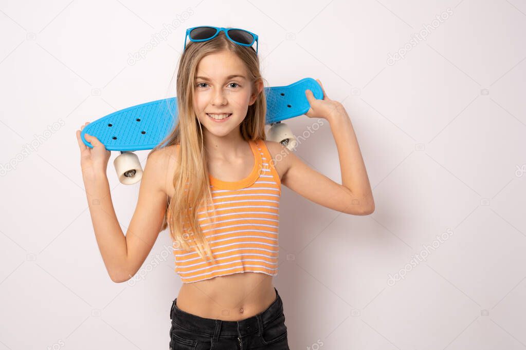 Portrait of beautiful young girl holding skate board in hand isolated on white background