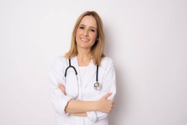İzole edilmiş arka planda, kolları çaprazlanmış, beyaz arka planda sırıtan genç bir doktor. Tıbbi konsept.