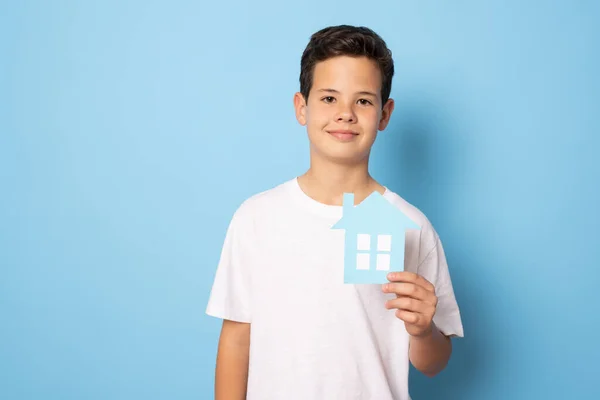 Bambino Possesso Carta Casa Isolato Sfondo Blu Immobiliare Concetto Famiglia — Foto Stock