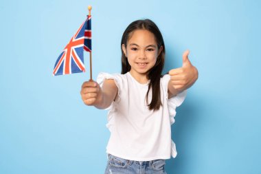 Birleşik Krallık / İngiltere bayrağı taşıyan tatlı bir genç kız. İngiliz bayrağı. İngilizce öğren. Uluslararası dil okulu konsepti