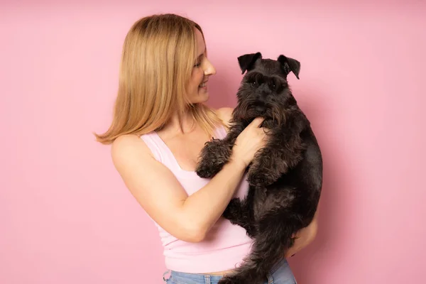 귀여운 여자가 강아지 슈나우저 껴안는다 사이의 배경에 고립되어 있습니다 스튜디오 — 스톡 사진