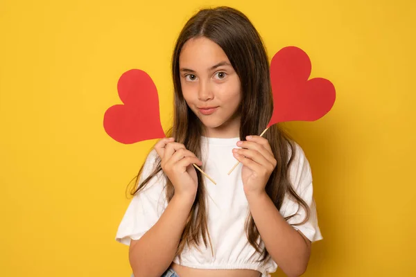 Dziewczyna Dwoma Kartonowymi Figurkami Małego Serca Stojącego Żółtym Tle Pojęcie — Zdjęcie stockowe