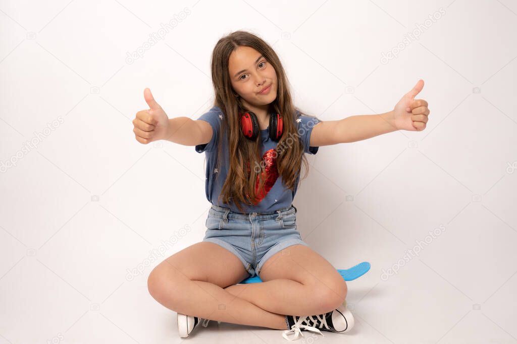 Young caucasian woman isolated on white background sitting in a skate and showing thumbs up.
