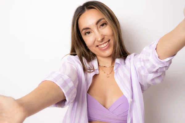 Friendly woman wearing summer outfit with an open hand ready for hugging standing isolated over white background.