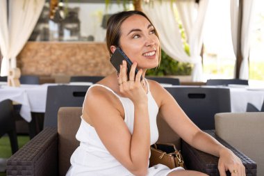 Genç, çekici bir kadın cep telefonuyla arıyor. Boş zamanlarında kafede tek başına oturuyor. Güzel gülüşlü çekici bir kadın kafede dinlenirken cep telefonuyla konuşuyor.