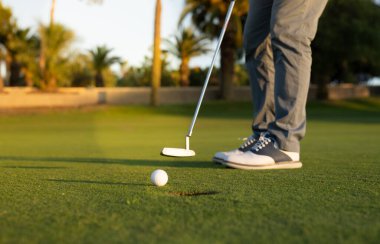 Yeşil çimlerin üzerinde golf topu vurmaya hazır..