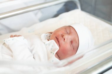 yeni doğmuş. Bebek yeni doğdu. Hastane doğum hastanesinde gözleri kapalı bir şekilde yatıyor. Yaşam tarzı mutlu aile bebek hayali konsepti. Battaniyeye sarılmış yeni doğmuş şirin bebek.