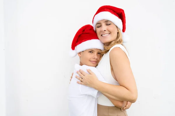 Mãe Filho Chapéus Papai Noel Sorrindo Desfrutando Temporada Natal Parede — Fotografia de Stock