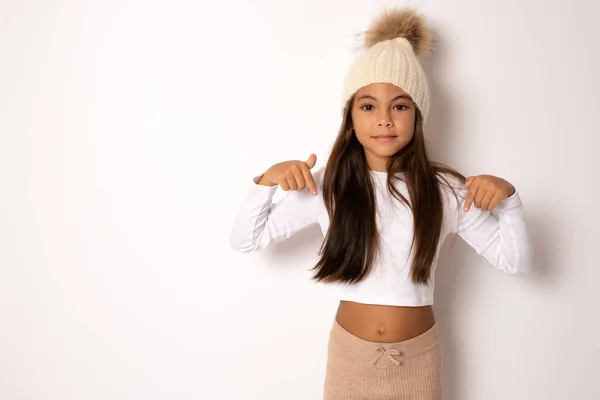 Pretty Brunette Little Girl Winter Hat Pointing Finger Isolated Whit — Stock Photo, Image