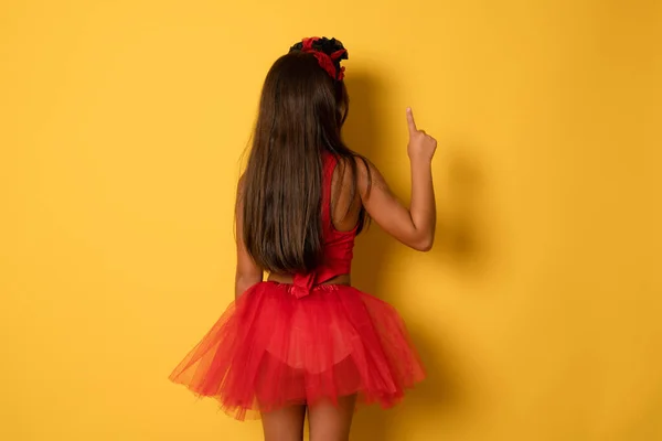 Pohled Zezadu Malou Holčičku Červeném Halloweenském Kostýmu Ukazující Prstem Žluté — Stock fotografie