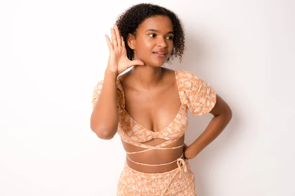耳に噂やゴシップに耳を傾け手で笑みを浮かべてカジュアルな夏の服を着て巻き毛を持つ若い美しいアフリカのアフロ女性 病気の概念 — ストック写真