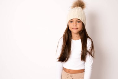 Örgü şapka takan mutlu küçük kızın kış portresi. Beyaz arka plandaki çocuk. Moda konsepti.