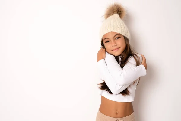 Menina Sorridente Bonito Usando Chapéu Inverno Abraçando Fundo Branco — Fotografia de Stock