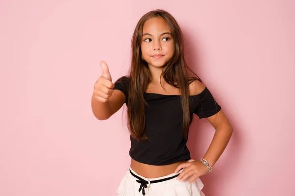 Маленькая Улыбающаяся Девочка Показывает Большой Палец Вверх Глядя Сторону Розовом — стоковое фото