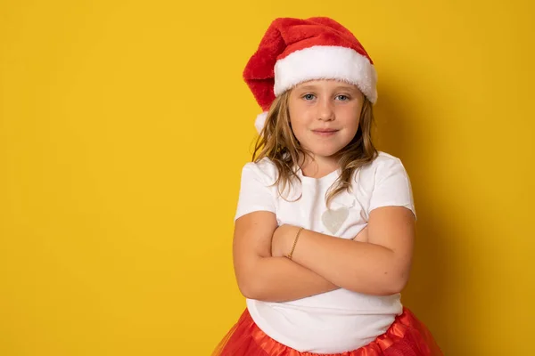 Menina Chapéu Vermelho Papai Noel Com Braços Dobrados Fundo Amarelo — Fotografia de Stock