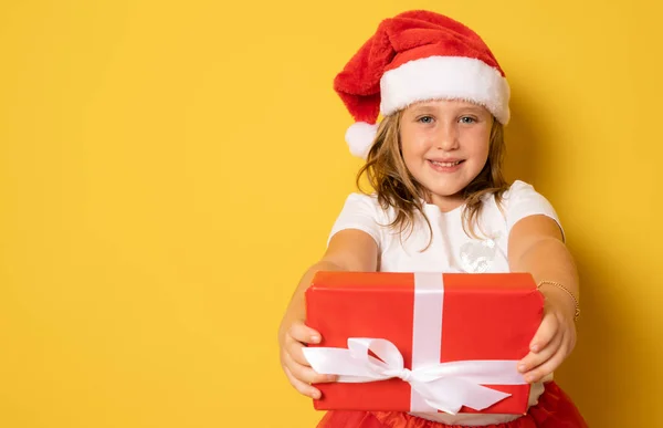 Nettes Kleines Mädchen Mit Weihnachtsmütze Steht Isoliert Über Gelbem Hintergrund — Stockfoto