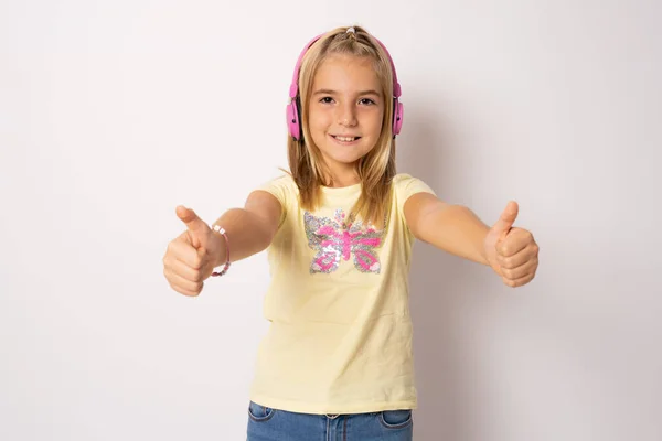 Фотопортрет Маленькой Девочки Улыбающейся Наушниках Слушающей Музыку Показывающую Большие Пальцы — стоковое фото