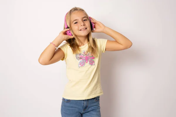 Portret Dziewczynki Uśmiechniętej Dotykającymi Słuchawkami Słuchającej Muzyki Odizolowanej Białym Tle — Zdjęcie stockowe