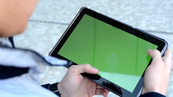 El hombre trabaja en la tableta (pantalla verde) en la calle — Vídeos de Stock