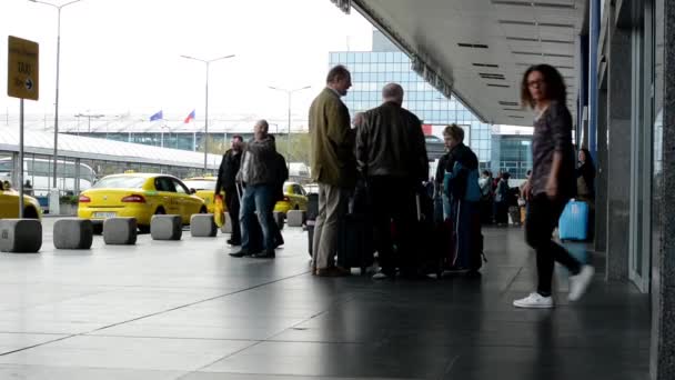 Аэропорт - люди за пределами аэропорта с машинами такси, припаркованными снаружи — стоковое видео