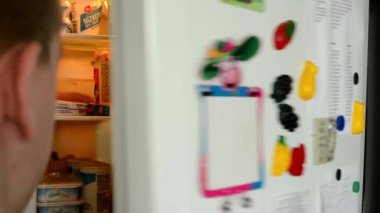 buzdolabına bakmak için bir adam gider