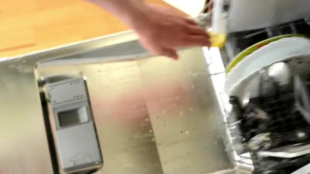 Man gives dirty dishes in to the dishwasher — Stock Video