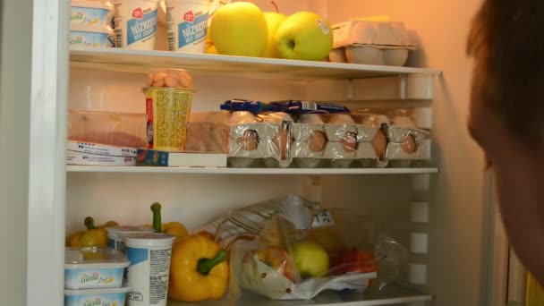 Mann geht immer noch zum Kühlschrank und weiß nicht, was er nehmen soll (Zeitraffer)) — Stockvideo