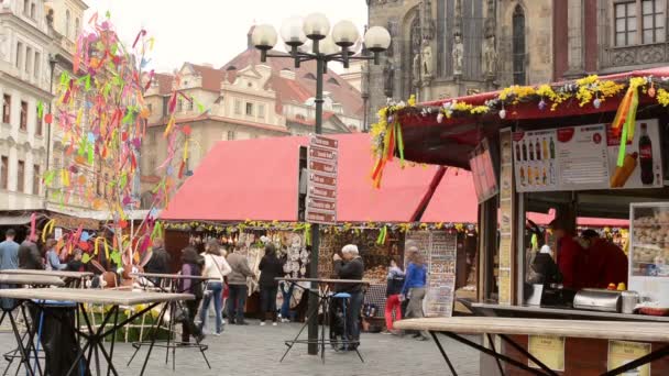 Easter markets - shops with people and directory of way (lamp). Old Town Square in Prague. — Stock Video