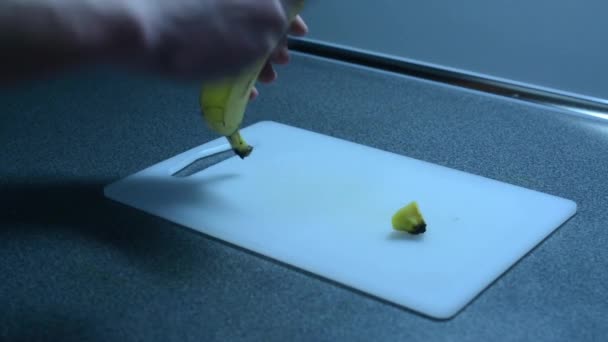 Очистка банана на кухонном столе — стоковое видео