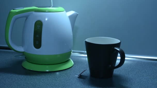 Boil water in a kettle and pouring tea on the kitchen counter — Stock Video