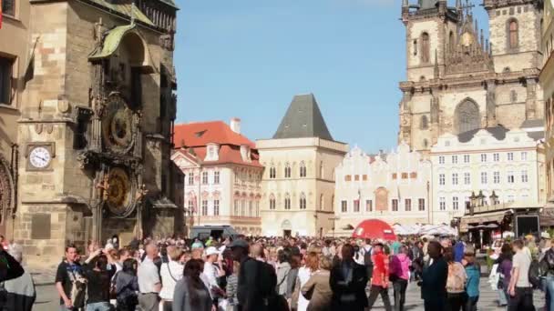 Староместская площадь с людьми и астрономические часы - в фоновом историческом здании - солнечный день — стоковое видео