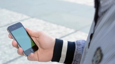 adam smartphone vasıl sokağa bakar.