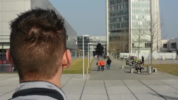 Een man staat en ziet er op de straat — Stockvideo