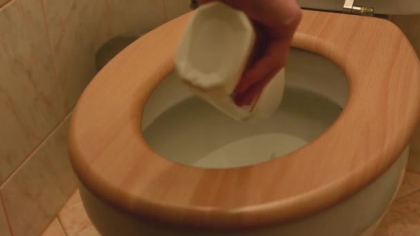 A man cleans a toilet using a disinfectant — Stock Video