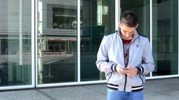 Homem trabalha em um smartphone e celular — Vídeo de Stock