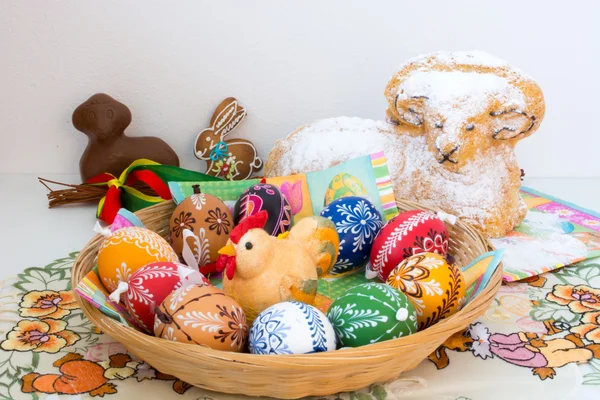 Osterdekoration - bemalte Eier im Korb und ein Widder zum Essen — Stockfoto